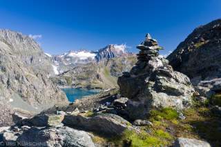 Steinmännchen im Vordergrund, hinten Bergsee, Gletscher und Gipfel